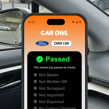 Car Owl app displaying vehicle check status as passed on a phone screen in a car interior